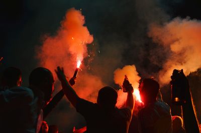 Rear view of people enjoying music concert at night