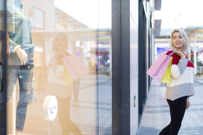 Portrait of young woman standing in city