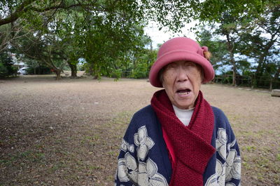 Senior woman wearing warm clothing standing at public park
