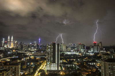 Illuminated cityscape against sky at night