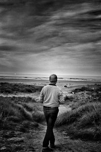 Rear view of man walking on beach