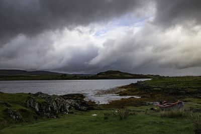 Scenic view of land against cloudy sky