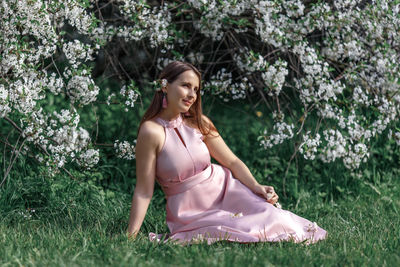 Portrait of young woman sitting on grass