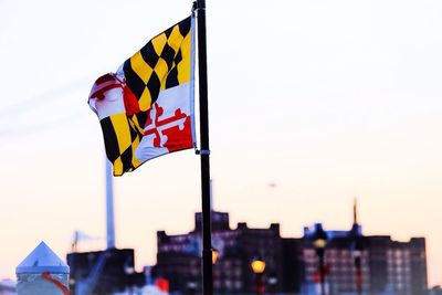 Low angle view of multi colored flag against cloudy sky