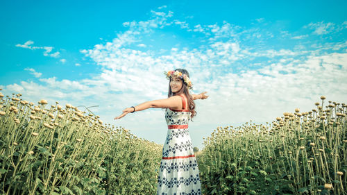 Woman standing on field against sky