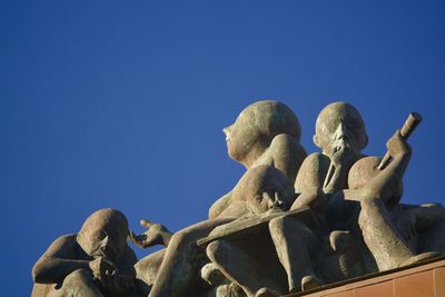 Low angle view of angel statue against clear blue sky