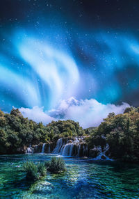 Scenic view of waterfall against sky at night