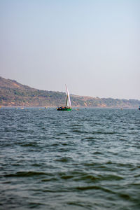 Sailboat sailing on sea against clear sky