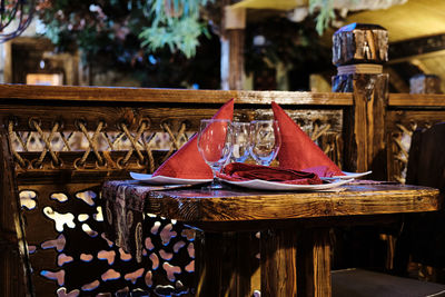 Table in the restaurant served glasses, plates and red napkins. beautiful wooden surroundings. 