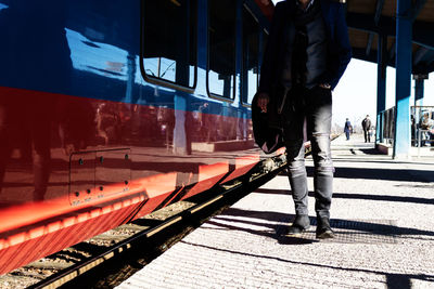 Unrecognizable businessman walking on railway station platform.