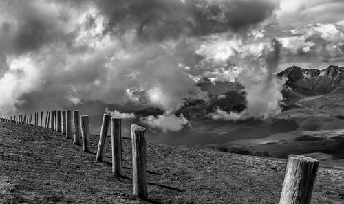 Panoramic view of wooden posts on field against sky