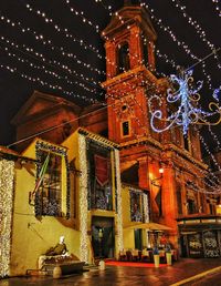 Illuminated clock tower in city at night