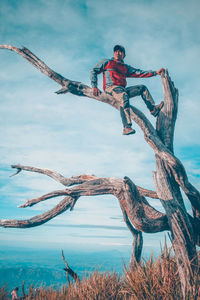 Full length of young man jumping in sea against sky