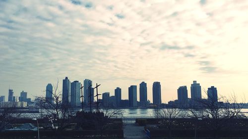 Modern cityscape against cloudy sky