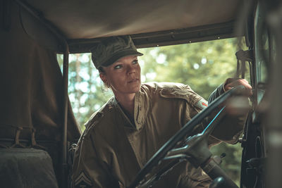 Woman soldier holding steering wheel of car