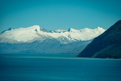 Scenic view of snowcapped mountains against blue sky