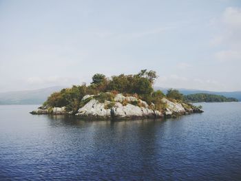 Rock formation on sea against sky