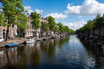 Boats moored on canal amidst buildings