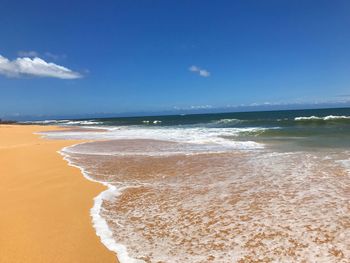 Scenic view of beach against blue sky