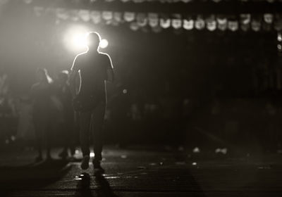 People walking on illuminated street at night