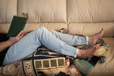 High angle view of woman lying on sofa at home