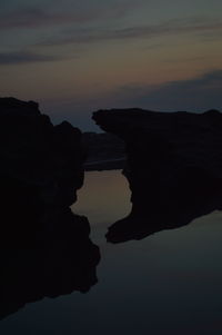Silhouette rock against sky during sunset