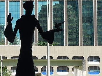 Rear view of man standing by window