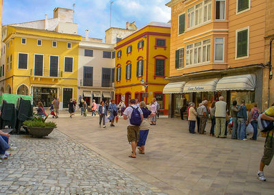 People on street in city against sky