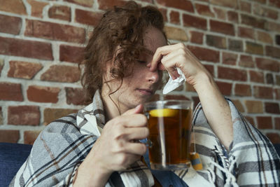 Midsection of woman holding drink at home