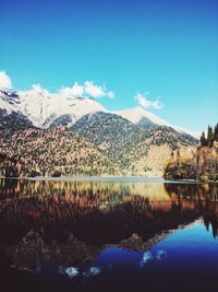 Scenic view of lake and mountains against blue sky