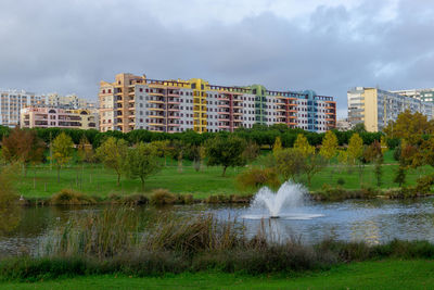 Lake by buildings against sky