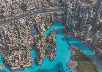 High angle view of swimming pool by river against buildings