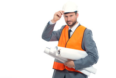 Young man wearing hat holding camera against white background