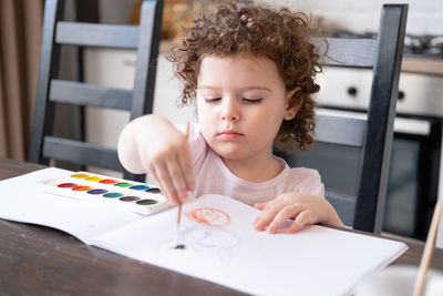 Cute girl painting on book