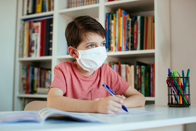 Boys wearing flu mask while studying at home