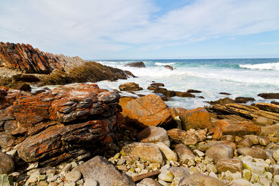 Rocks on beach against sky