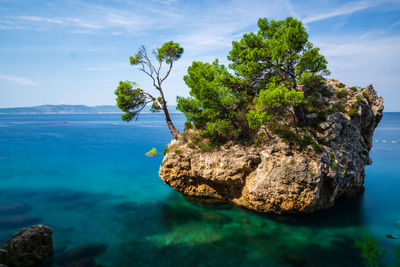 Rock formation in sea against sky