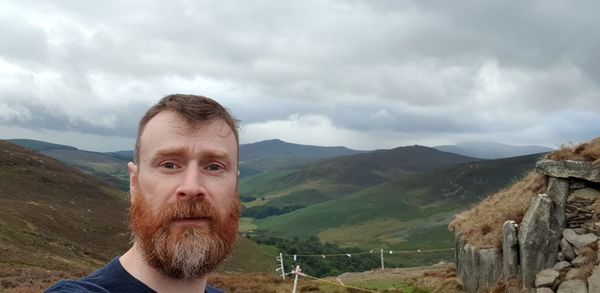 Portrait of young man against mountains