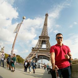 Tourists in city against cloudy sky