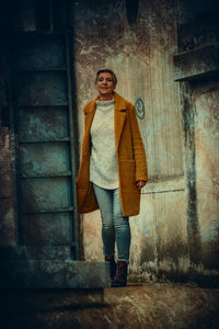 Portrait of woman standing against wall