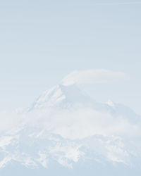 Aerial view of snowcapped mountains against clear sky