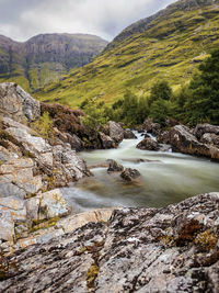 Scenic view of river amidst mountains against sky