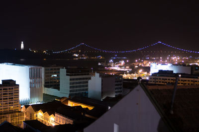 Illuminated cityscape against clear sky at night