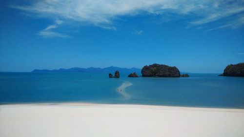 Scenic view of sea against blue sky on sunny day