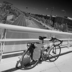 High angle view of bicycle leaning on railing at bridge over highway