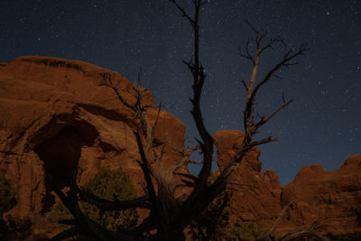 Low angle view of rock formation against sky at night