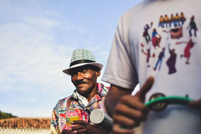 Close-up of smiling man against sky