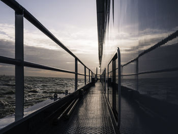 Bridge over calm sea against sky