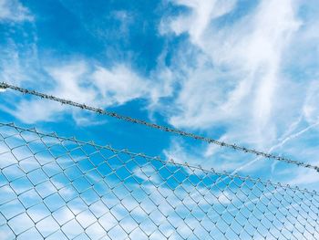 Low angle view of chainlink fence against sky