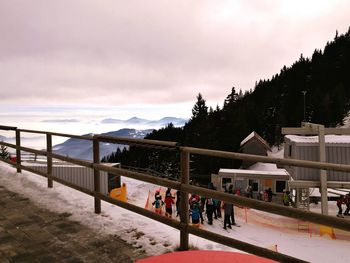 People on snow covered mountain against sky